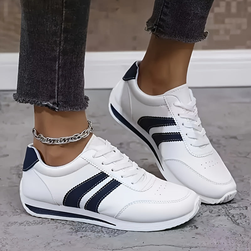 White low-top trainers with navy stripes, round toe and lace-up fastening